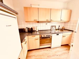 a small kitchen with wooden cabinets and a sink at 2-Zimmer Wohnung in Bremen-Vahr in Bremen