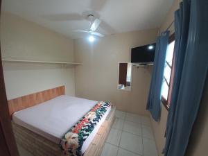 a small bedroom with a bed and a window at Pousada Belas Praia quarto Praia da Vila in Imbituba