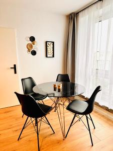 a dining room with a glass table and four chairs at 2-Zimmer Wohnung in Bremen-Vahr in Bremen
