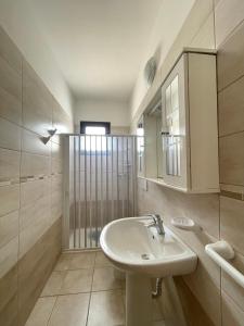a bathroom with a sink and a mirror at Casa Crono - Casa indipendente, fronte mare in Marina di Pescoluse