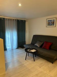 a living room with a green couch and a table at Un coin en Provence in Villeneuve +2 photos