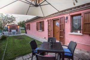 une terrasse avec une table et des chaises sous un parasol dans l'établissement Casa di Marco e Kaila, à Tavullia