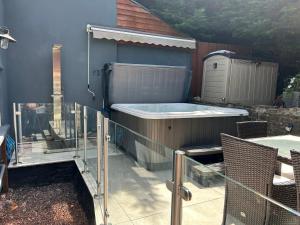 a hot tub on the side of a house at Honeycott in Crickhowell