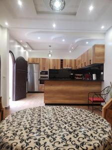 a large kitchen with wooden cabinets and a large table at villa najia in Oualidia