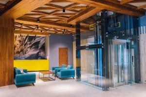 a lobby with blue chairs and a yellow wall at The Valley Residence & Spa SUITE 223 in Bakuriani