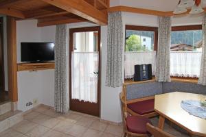 a dining room with a table and a television at Acherkogelblick in Oetz