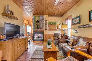a living room with a couch and a tv at Granby Cabin Rental on Fraser River - Fish and Ski! in Granby
