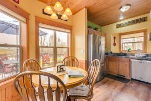 eine Küche mit einem Holztisch und Stühlen in der Unterkunft Granby Cabin Rental on Fraser River - Fish and Ski! in Granby