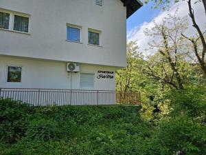 a white house with a sign on the side of it at Apartman Heli Meli 1 in Jajce