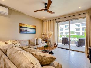 a living room with a large couch and a ceiling fan at New Condo! Vista Velas III in El Pueblito