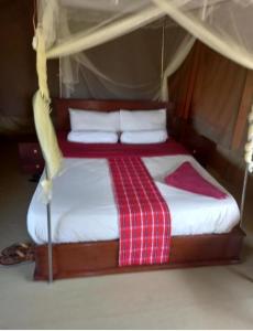 a bedroom with two beds with red and white sheets at Emayian sekenani camp in Sekenani