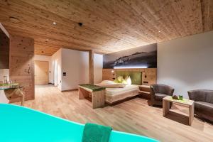 a hotel room with a bed and a couch at Luxury and Nature House Moarlhof in Castelrotto