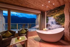 Cette chambre dispose d'une baignoire et offre une vue sur une cascade. dans l'établissement Luxury and Nature House Moarlhof, à Castelrotto