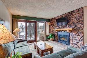 a living room with a couch and a fireplace at Sawmill Creek Condo 207 by Great Western Lodging in Breckenridge