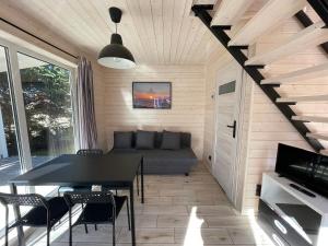 a living room with a couch and a table and chairs at FOLGI - Domki Kopalino in Kopalino