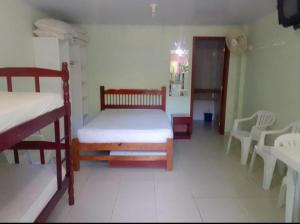 1 Schlafzimmer mit 2 Etagenbetten sowie einem Tisch und Stühlen in der Unterkunft Pousada Termas Piratuba in Piratuba