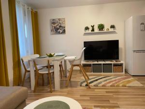a living room with a television and a table and chairs at Sunny Hill Sandanski in Sandanski