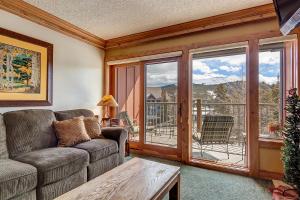 a living room with a couch and a balcony at Sawmill Creek Condo 302 by Great Western Lodging in Breckenridge