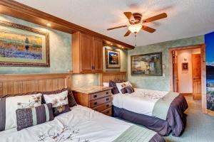 a bedroom with two beds and a ceiling fan at Sawmill Creek Condo 302 by Great Western Lodging in Breckenridge +11 photos