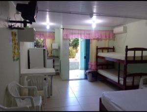 a room with bunk beds and a kitchen with a door at Pousada Termas Piratuba in Piratuba