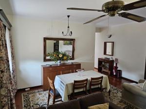 a living room with a table and a ceiling fan at Apartamento Mondego in Penacova