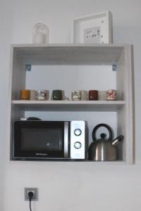 a shelf with a microwave and a tea pot on it at Apartamento La esquina del Castillo in Caravaca de la Cruz
