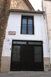 a white building with two garage doors and two windows at Apartamento La esquina del Castillo in Caravaca de la Cruz