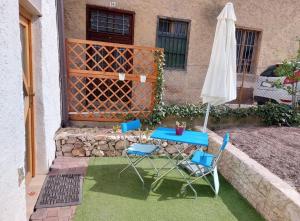 a patio with a table and chairs and an umbrella at Ferienzimmer (Stanza) in Fondo Trentino in Fondo
