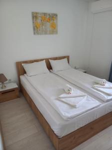 een bed met witte lakens en 2 handdoeken erop bij Pensiunea Apartamente 9 Sofia & David in Baile Felix