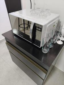 un microondas sentado en la parte superior de un mostrador con gafas en Executivo Veneza, en Ipatinga