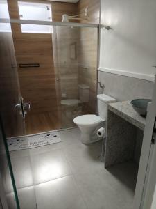ein Bad mit einer Dusche, einem WC und einem Waschbecken in der Unterkunft Executivo Veneza in Ipatinga