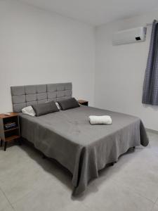 a bedroom with a large bed with two towels on it at Executivo Veneza in Ipatinga