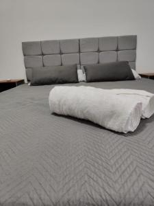 ein großes Bett mit einer weißen Decke drauf in der Unterkunft Executivo Veneza in Ipatinga