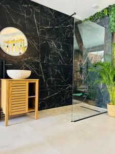 LéguevinにあるLove Room Toulouseの洗面台とガラスのシャワーを備えたバスルーム
