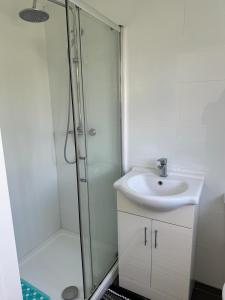 a white bathroom with a sink and a shower at A cosy 8 Bedroom House in Edmonton