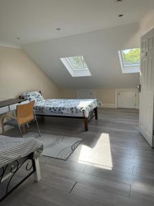 a room with two beds and a table and skylights at A cosy 8 Bedroom House in Edmonton