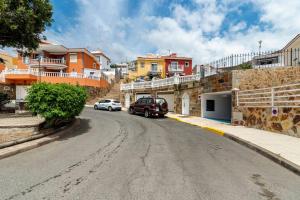 ulica z samochodami zaparkowanymi po stronie drogi w obiekcie Villa Aspen Gran Canaria w mieście Arguineguín