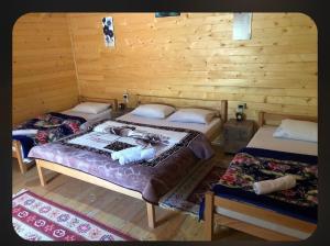 a room with three beds in a log cabin at 2E Villa’s Valbone in Valbonë