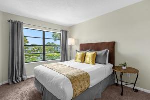 a bedroom with a large bed and a window at Modern Cozy 2BR Condo Near Disney in Orlando