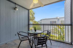 a patio with a table and chairs on a balcony at Modern Cozy 2BR Condo Near Disney in Orlando