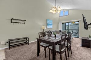 a dining room and living room with a table and chairs at Modern Cozy 2BR Condo Near Disney in Orlando