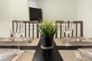 a table with two wine glasses and a potted plant at Modern Cozy 2BR Condo Near Disney in Orlando