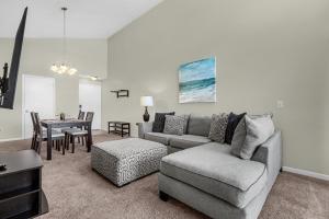 una sala de estar con un sofá y una mesa en Modern Cozy 2BR Condo Near Disney, en Orlando
