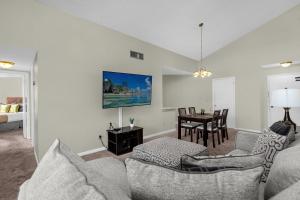 a living room with a couch and a table at Modern Cozy 2BR Condo Near Disney in Orlando +29 photos