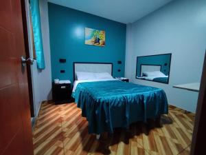 a blue bedroom with a bed with a blue bedspread at Hostal El Pilar in Lima