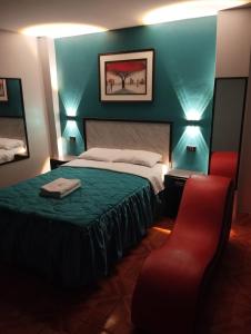 a bedroom with a bed and a red chair at Hostal El Pilar in Lima