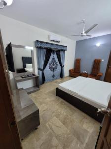 1 dormitorio con 1 cama grande y espejo en Blue diamond guest house en Karachi