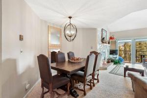 Un comedor con mesa y sillas de madera. en Sawmill Creek Condo 406 by Great Western Lodging, en Breckenridge