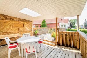 a patio with a white table and chairs on a wooden deck at Stunning Home with Large Patio Sundeck in Toronto