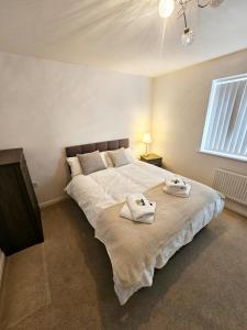 um quarto com uma cama grande e toalhas em Spacious Modern 4BD House em Hull